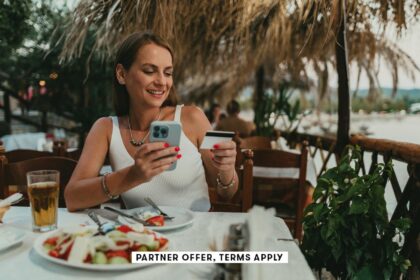 SOCIAL IMAGE PARTNER OFFERS TERMS APPLY Woman using a smartphone and paying with a credit card in a restaurant cream ph 25